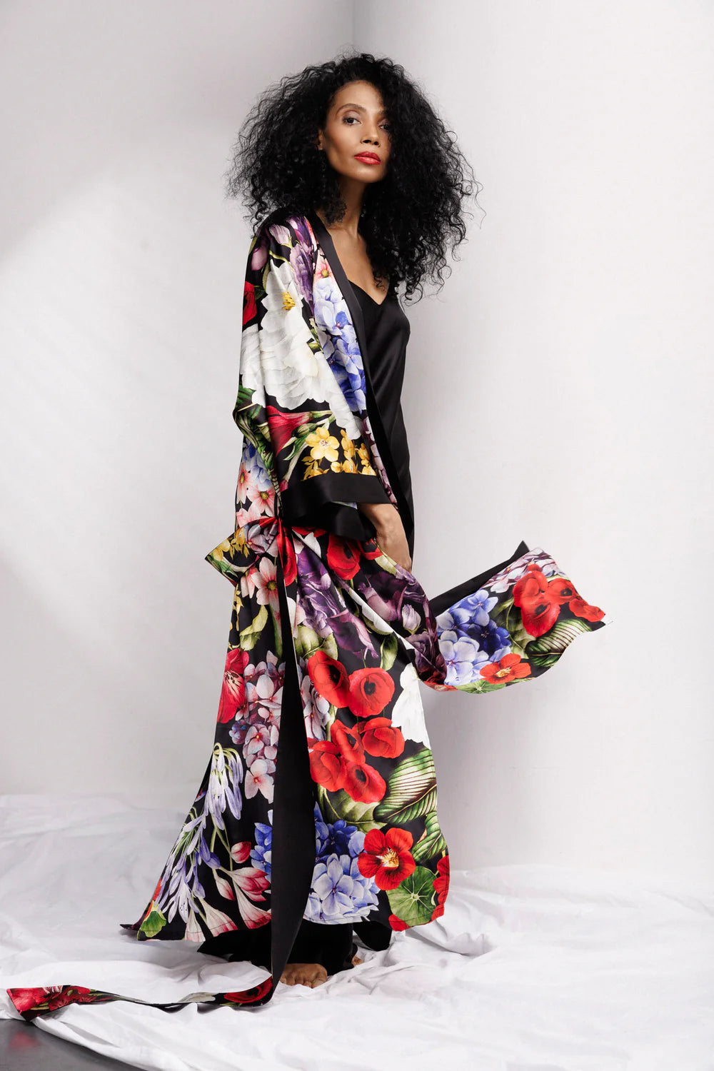 Woman wearing a colorful floral silk kimono over full length nightgown, sold separately. Showing the side part